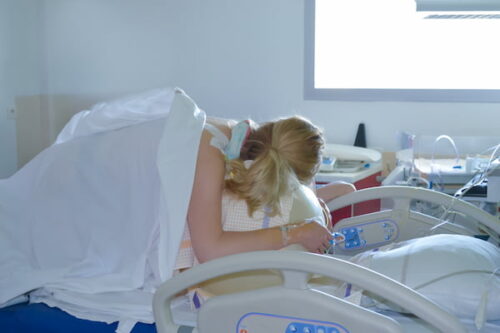 woman laying on side in hospital.