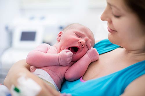 woman holding newborn infant.