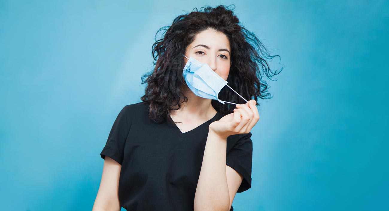 woman removing face mask.